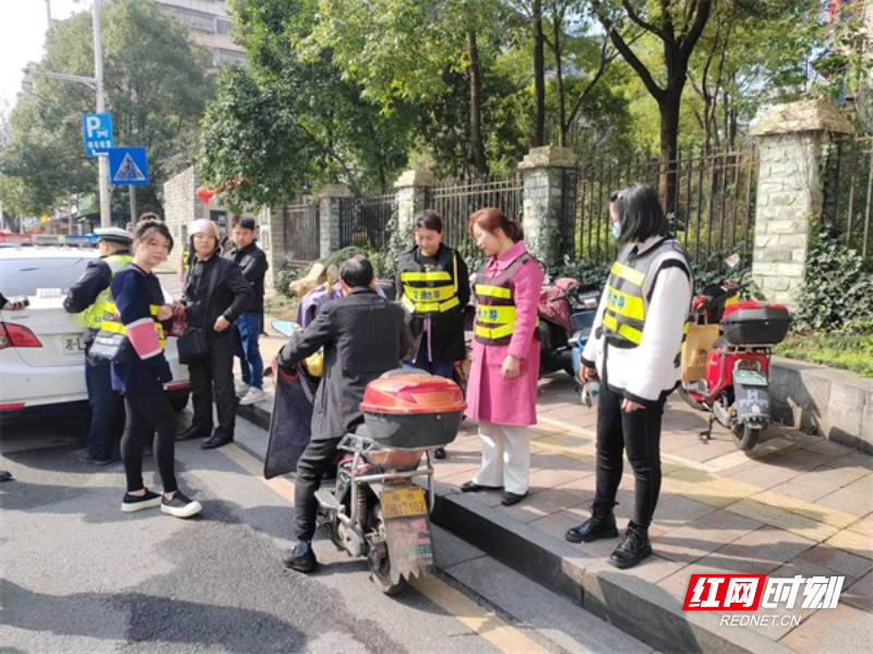 图二街道、村（社区）劝导员对不带头盔骑乘电动车人员进行劝导。（周阁惇  摄）.jpg